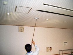 室内の天井まわりの建築設備を点検している様子